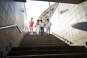 Four cheerful friends walking in city centre