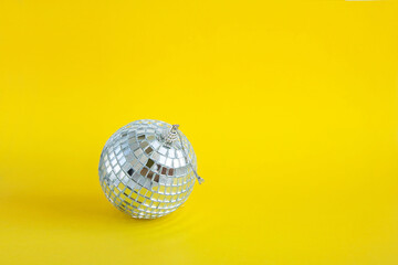 a ball of disco mirror pieces on a yellow monochrome background