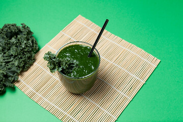 Aojiru - Traditional Japanese drink. Prepared with fresh green vegetables and kale leaves. The healthy drink is also used in alternative medicine. Top view, selective focus, copy space