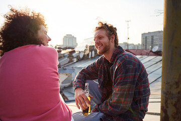 Cheerful young man and woman relaxing on roof