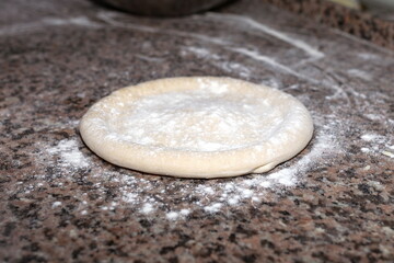 Rolled out pizza dough on floured slate surface. Horizontal image