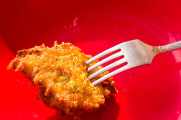 Fried vegetable fritters with zucchini, carrots, herbs, eggs, and cheese.
