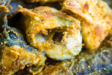 Pieces of navaga fish in batter, fried in oil in a pan.
