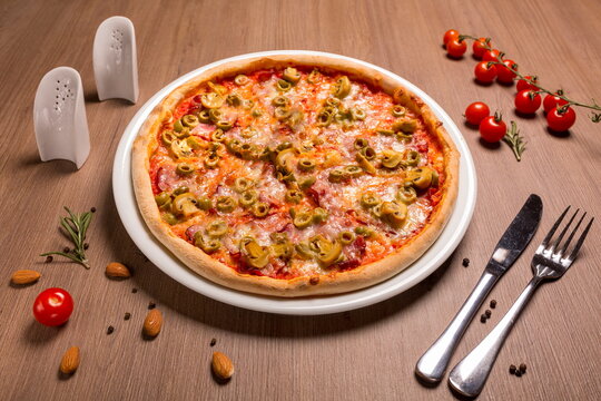 Capricciosa pizza thin cake, tomato sauce, ham, olives, marinated mushrooms mozzarella basil