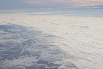 white clouds on the ground covered with snow, blue sky, winter