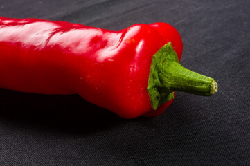 Fresh organic red chili peppers on a black background, close-up