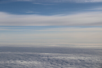 Fototapeta na wymiar beautiful white clouds on blue sky, view from airplane window