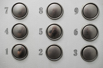 metal buttons with numbers from one to nine on a gray background