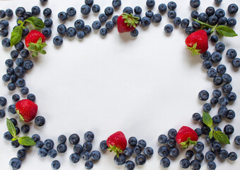 Fresh fruits. Healthy food. Mixed fruits, strawberries and blueberries. Studio photography of various fruits on a white table. Organic healthy assorted fruits. Assortment of fresh fruits. Fruit food b