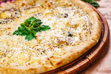 Italian Pizza four cheese (quattro fromaggi) on wooden cutting board. Close up