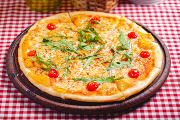 Pizza Margherita (Margarita) with fresh arugula on wooden board. Close up