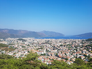 Fototapeta na wymiar beautiful view over the sunny city, sea and mountains, blue sky and green trees