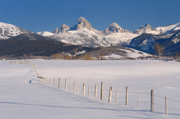 Fototapeta na wymiar Mount Owen Grand Teton Middle Teton and South Teton in winter from Idaho with fence