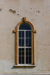 Vintage decorated high window with a rounded top on old house wall