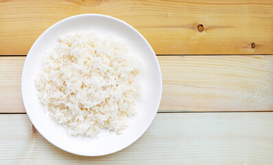 Dish of rice on wo0den background.
