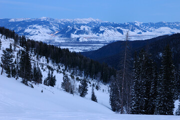 Teton Pass at dusk with lights of Jackson and the Rocky Mountains Jackson and Pinnacle Peaks in winter