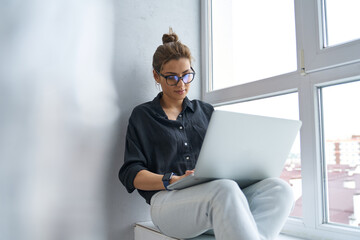 Calm businesswoman working online on laptop indoors