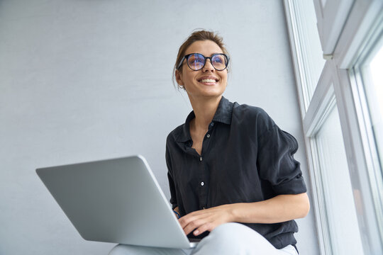 Jolly young woman using notebook for fun indoors