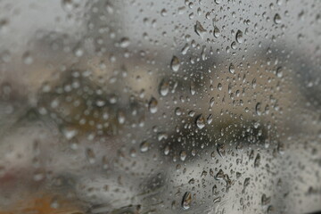 Raindrops on a misted glass with a soft multi-colored background