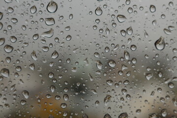 Raindrops on a misted glass with a soft multi-colored background