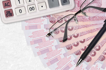 100 Thai Baht bills fan and calculator with glasses and pen. Business loan or tax payment season...