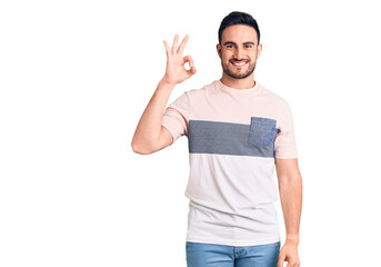Young handsome man wearing casual clothes smiling positive doing ok sign with hand and fingers. successful expression.