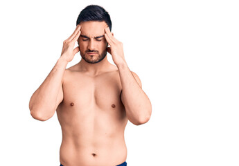 Fototapeta premium Young handsome man wearing swimwear suffering from headache desperate and stressed because pain and migraine. hands on head.
