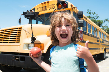 Excited pupils smiling at camera in the school bus outside the elementary school. Happy school kid....