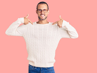 Young handsome man wearing casual clothes and glasses looking confident with smile on face,...