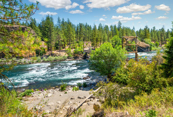 The rustic wooden suspension bridge over the Spokane River at the Bowl and Pitcher area of Riverside State Park, Spokane, Washington, USA