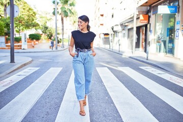 Beautiful young woman wearing fashionable clothes standing in the middle of the street at the town