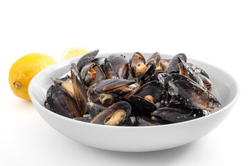 Protein and zinc rich sea food, marine delicacy and luxury foods concept with photograph of a bowl of raw mussels and lemons isolated on white background with clipping path cutout