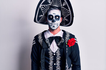 Young man wearing mexican day of the dead costume over white smiling looking to the side and staring away thinking.