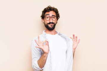 young cool bearded man with proud and satisfied expression