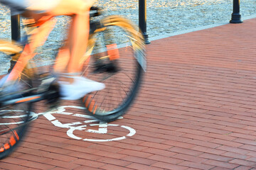 The cyclist is driving fast along the bike path, which has special white symbols. These signs allow him to move.