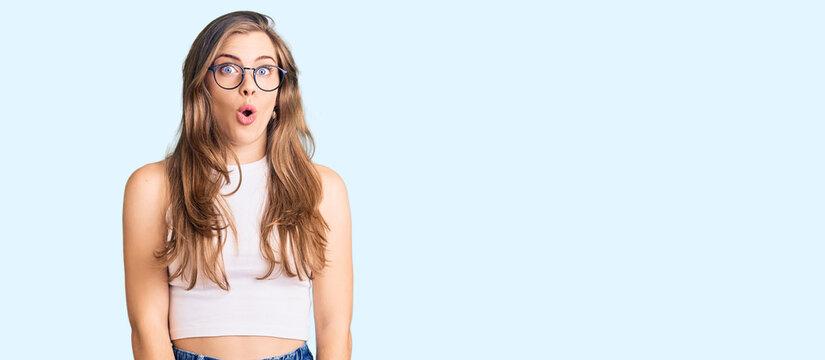 Beautiful caucasian young woman wearing casual clothes and glasses afraid and shocked with surprise expression, fear and excited face.