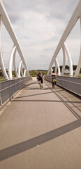 Obraz na płótnie Canvas pedestrian bridge over the river, bicycles, going in for sport