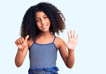 African american child with curly hair wearing swimwear showing and pointing up with fingers number six while smiling confident and happy.