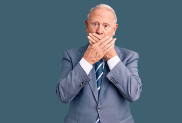 Senior handsome grey-haired man wearing elegant suit shocked covering mouth with hands for mistake. secret concept.
