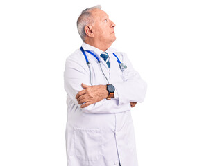 Senior handsome grey-haired man wearing doctor coat and stethoscope looking to the side with arms crossed convinced and confident