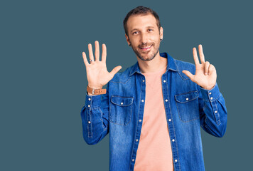 Young handsome man wearing casual clothes showing and pointing up with fingers number eight while smiling confident and happy.