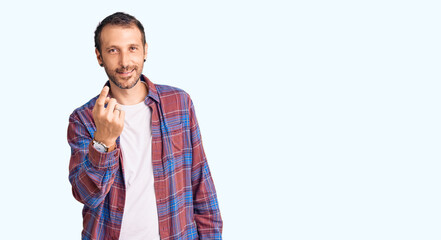 Young handsome man wearing casual clothes beckoning come here gesture with hand inviting welcoming happy and smiling