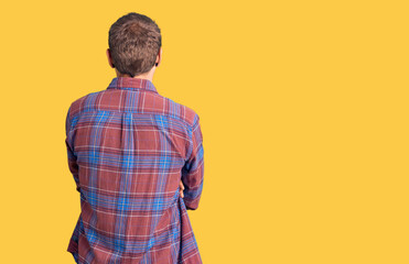 Young handsome man wearing casual clothes standing backwards looking away with crossed arms