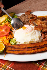 Primer plano de plato colombiano tradicional. Plato de comida popular de Antioquia Colombia con frijoles huevo, cero carne y plátano