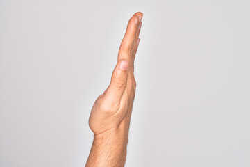 Hand of caucasian young man showing fingers over isolated white background showing the side of stretched hand, pushing and doing stop gesture