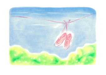 爽やかな青空にシューズが一足ひもにつるさっている、手前には庭の緑が見える

