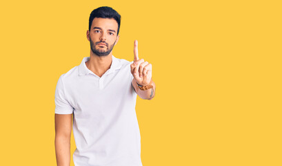 Young handsome hispanic man wearing casual clothes pointing with finger up and angry expression, showing no gesture