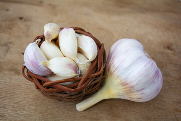 Cloves of raw Garlic in wooden small vintage nest as bowl. Spices for cooking