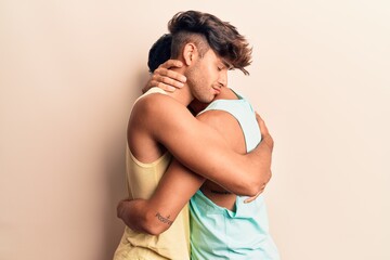 Fototapeta na wymiar Young couple of men wearing summer clothes smiling happy. Standing with smile on face hugging over isolated white background