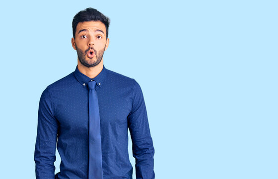 Young handsome hispanic man wearing business clothes scared and amazed with open mouth for surprise, disbelief face